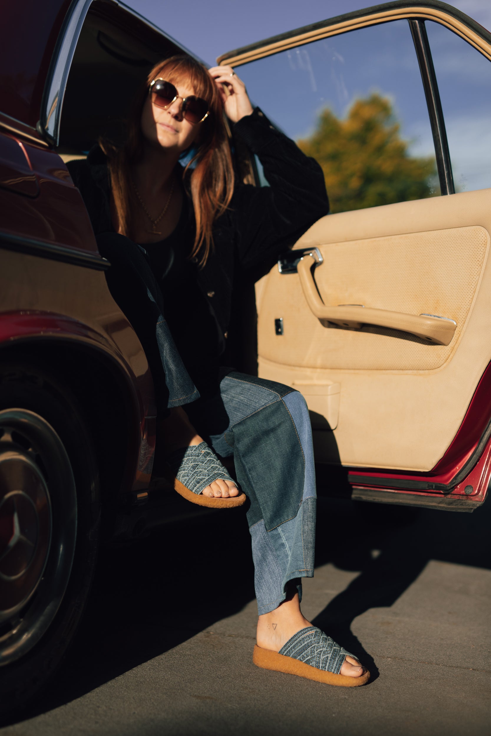 lifestyle photo of malibu sandals orlsow Zuma denim sandals being worn with blue jeans with the feet outside of a car